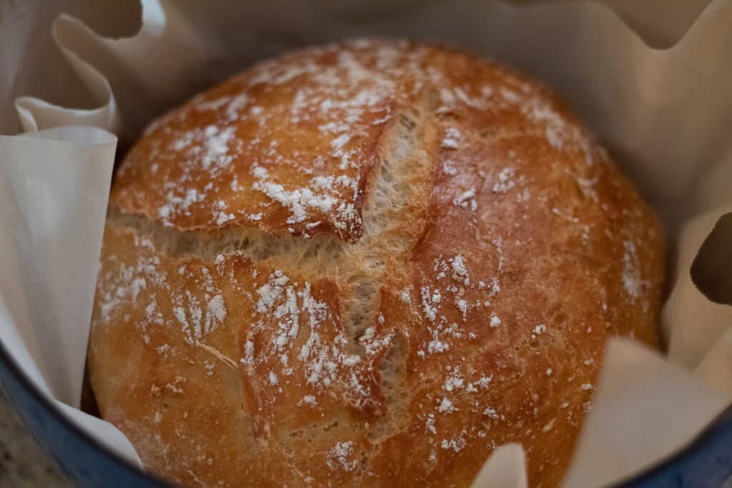 Up close shot of a baked loaf of bread in a dutch oven