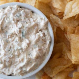 Bowl of french onion dip next to chips