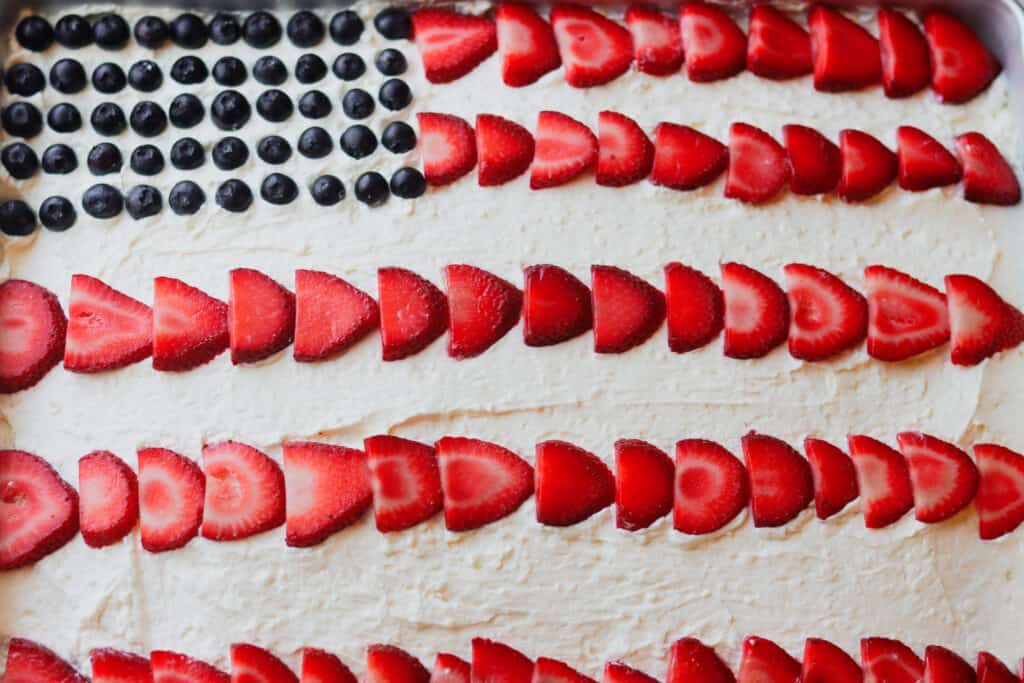 Mixed berry sheet cake with whipped mascarpone frosting and blueberries and strawberries styled to look like an American flag