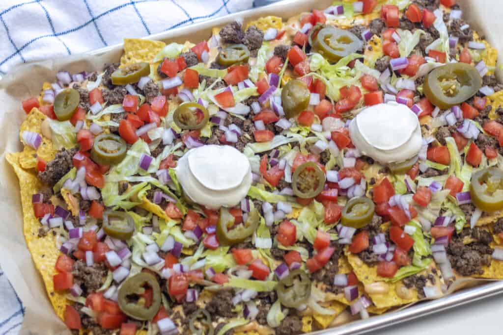 Platter of beef nachos topped with sour cream
