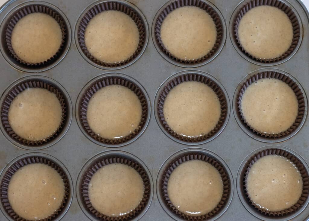 Uncooked cupcake batter in a lined cupcake pan