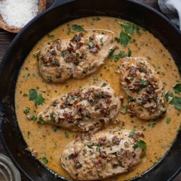 Pan with four chicken breasts in a creamy sundried tomato sauce