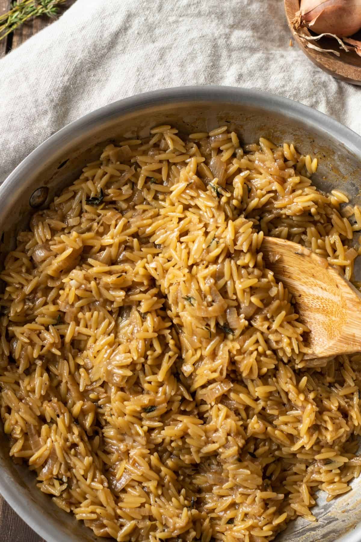 Garlic Parmesan Orzo in a pan with a wooden spoon