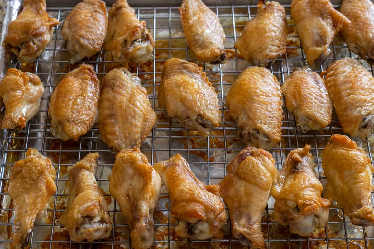 Baked wings on a rack inside a baking sheet.