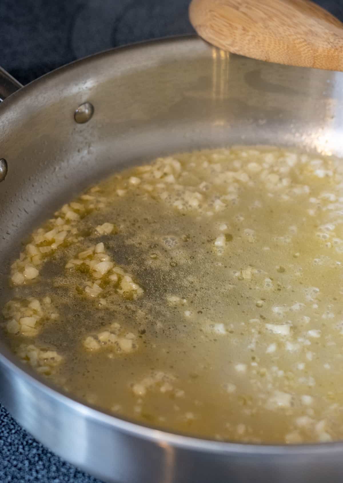 Butter, white wine, and minced garlic in a steel pan.