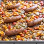 Italian sausages, diced bell peppers, and diced onions baked on a sheet pan.