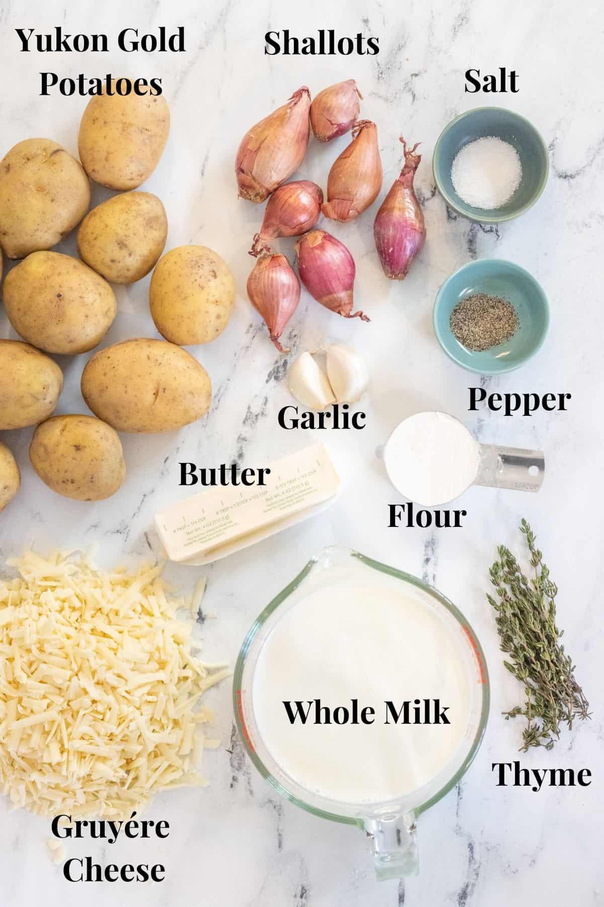 The ingredients for gruyére potatoes au gratin laid out on a counter with labels over each ingredient.