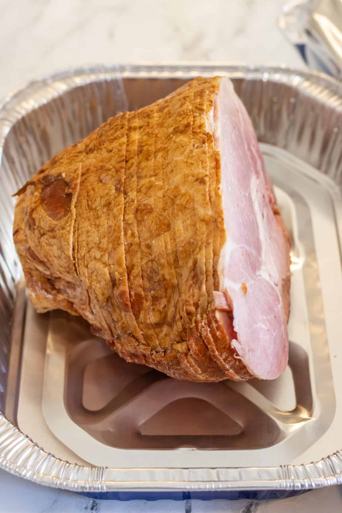 Spiral sliced ham in a disposable roasting pan.