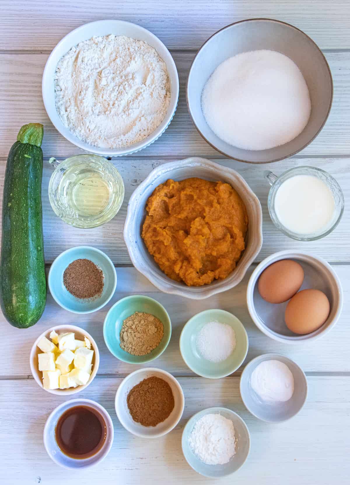 Ingredients for pumpkin zucchini muffins on a board.