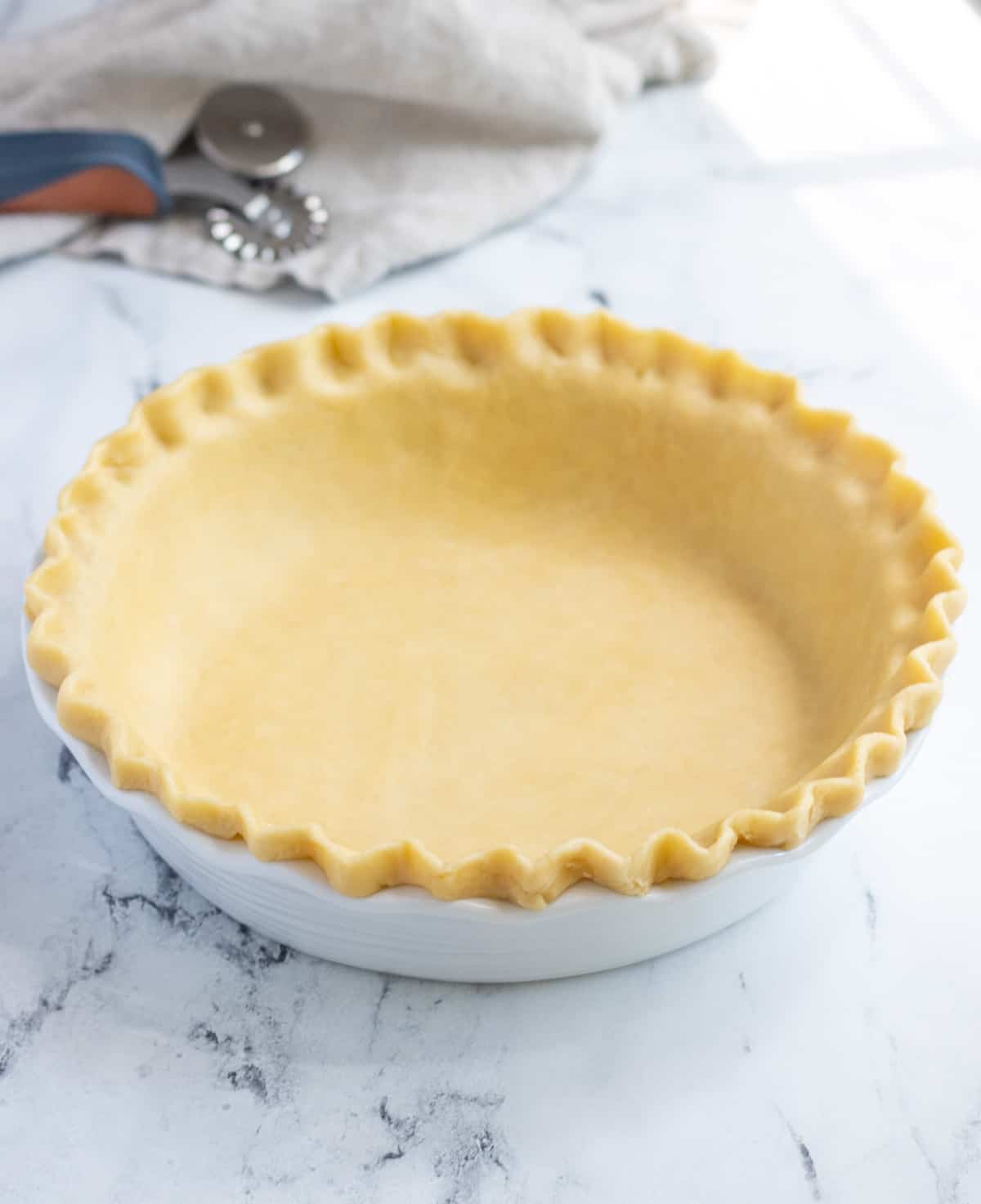 Unbaked pie crust with crimped edges in a pie plate.