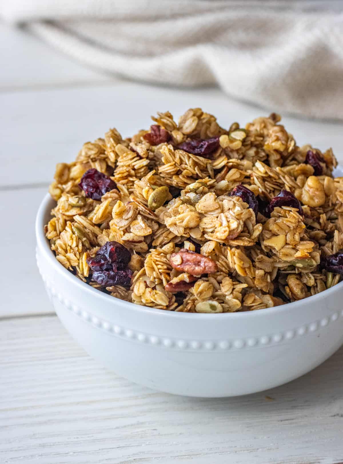 Bowl of granola with a cloth napkin in the background.