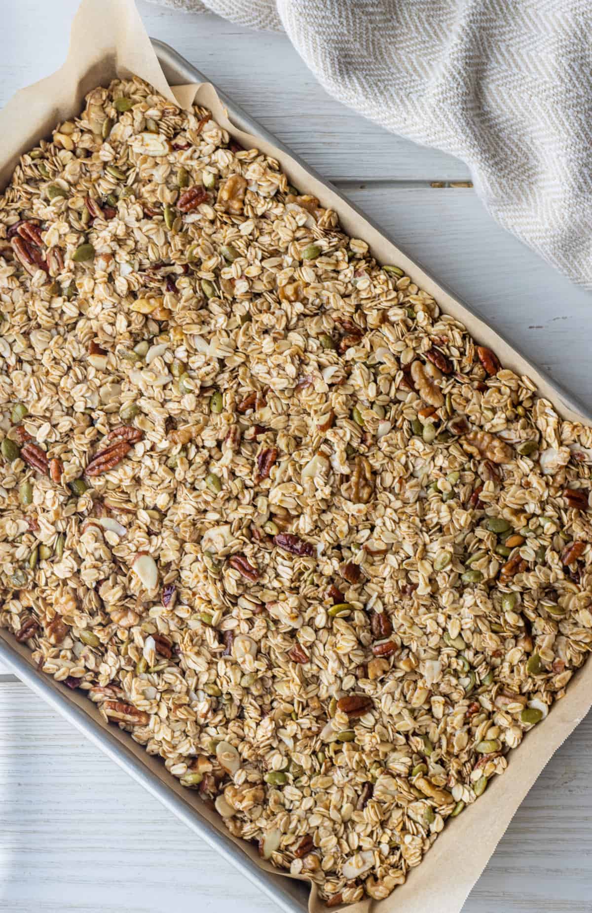 Baked granola on a parchment paper-lined baking sheet.