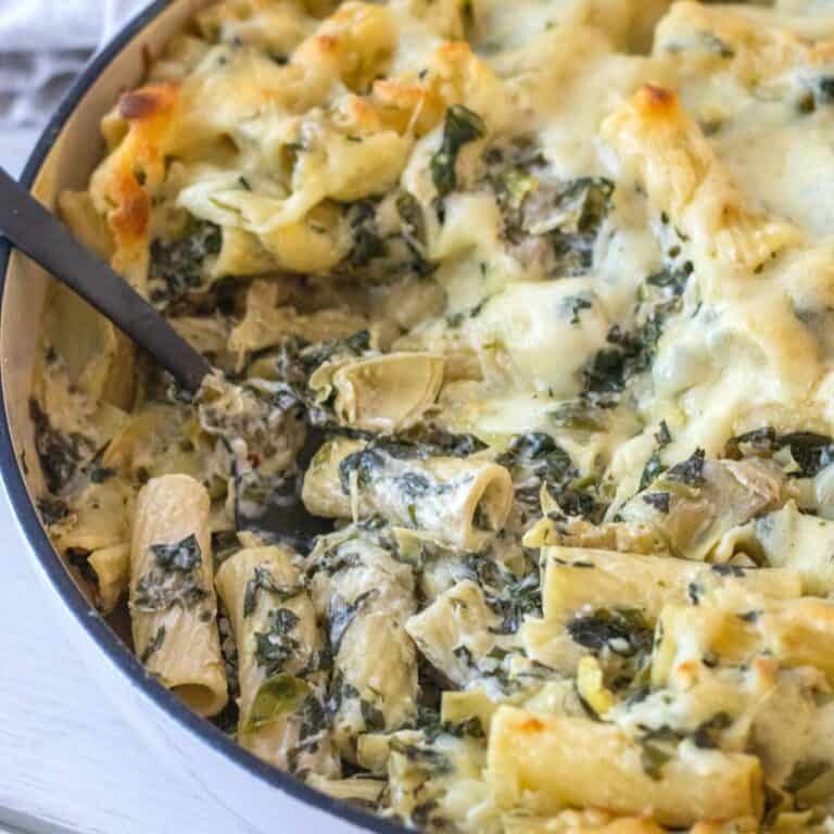 Spinach artichoke rigatoni noodles in a casserole dish.