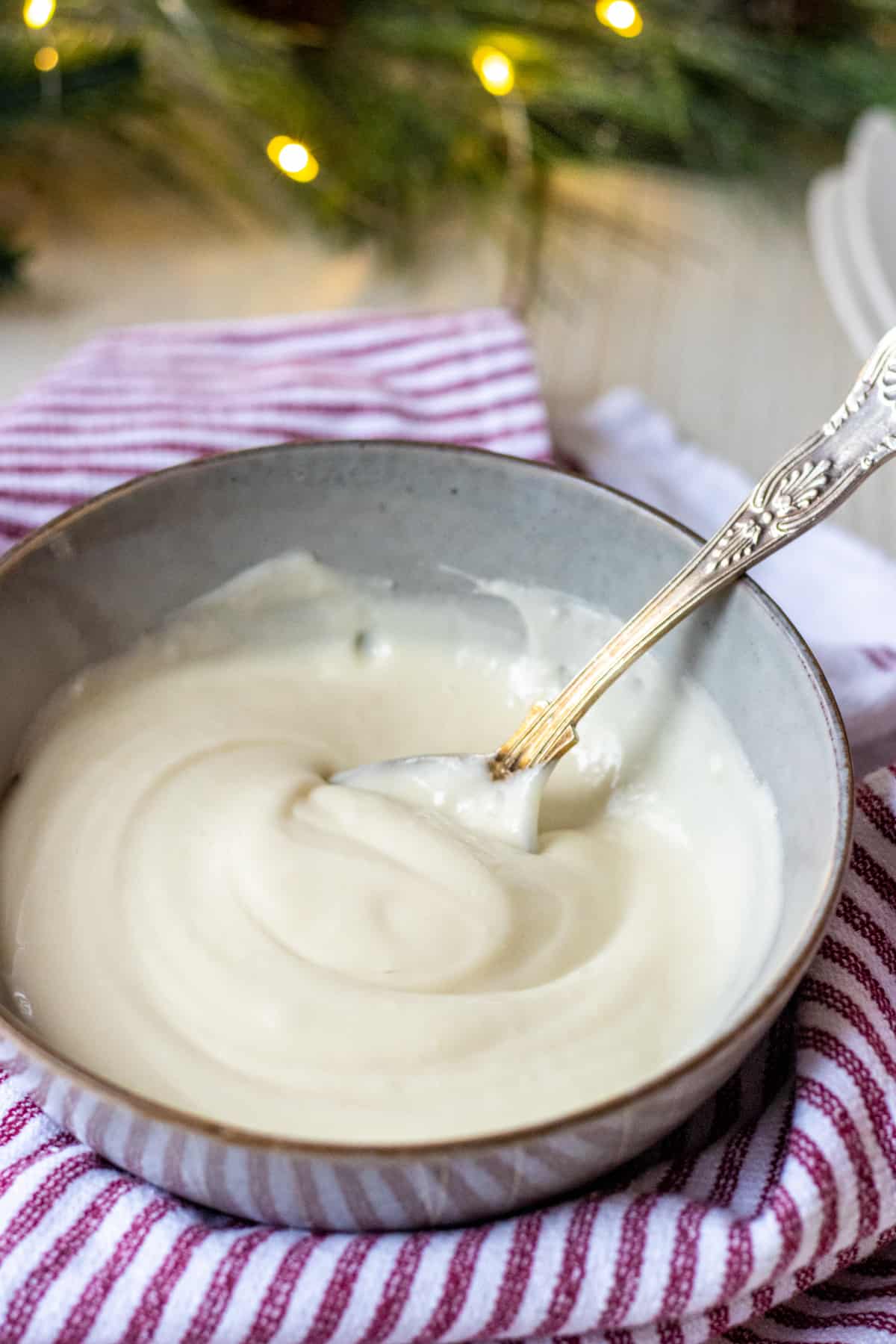 Bowl of cream cheese frosting with a spoon.