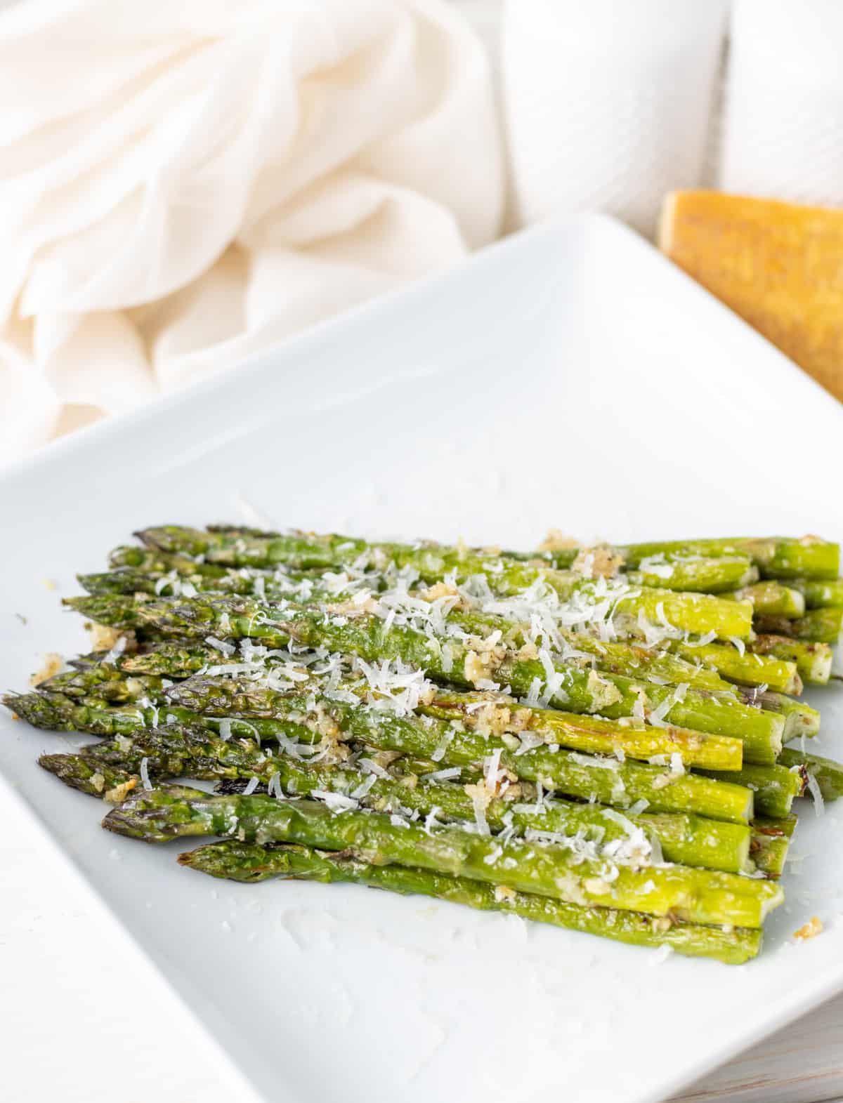 Asparagus topped with parmesan on a plate.