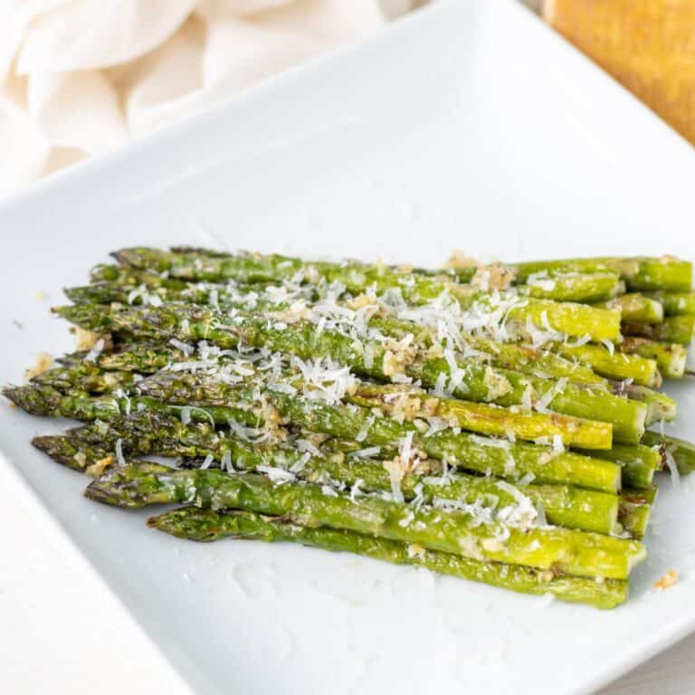 Garlic parmesan asparagus piled up on a plate.
