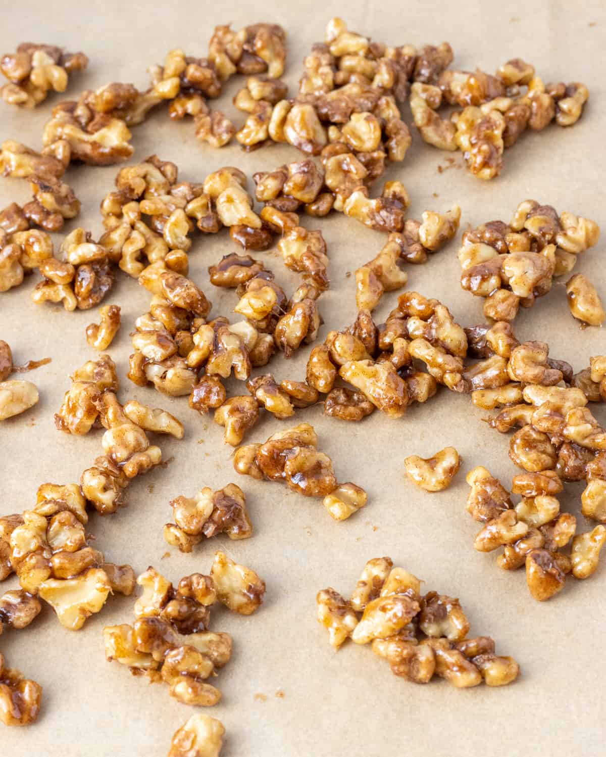 Candied walnuts on a parchment-lined baking sheet.