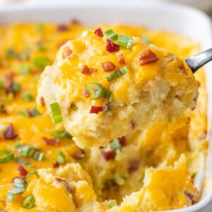 A large scoop of twice baked mashed potatoes on a spoon.