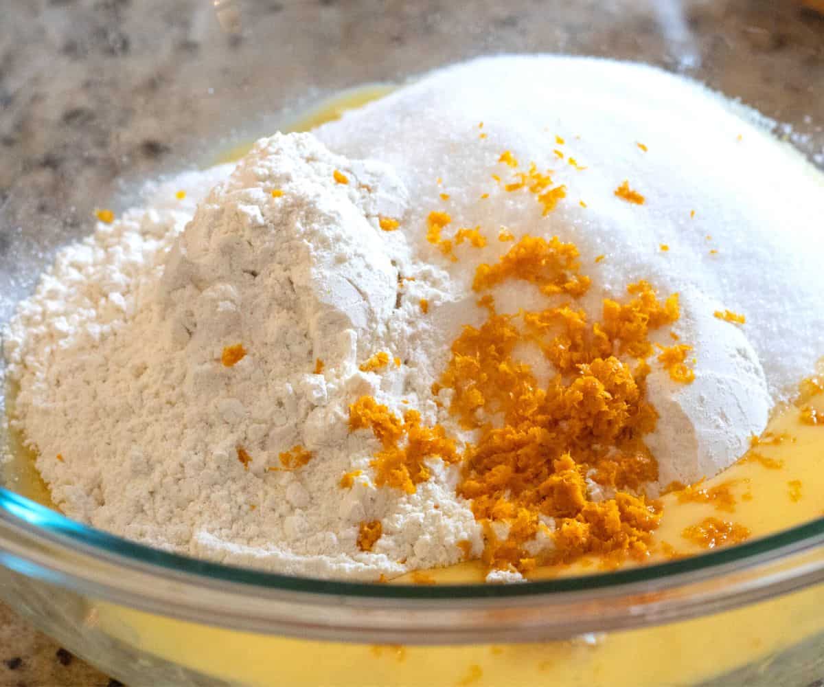 Melted butter, flour, sugar, orange zest in a bowl.