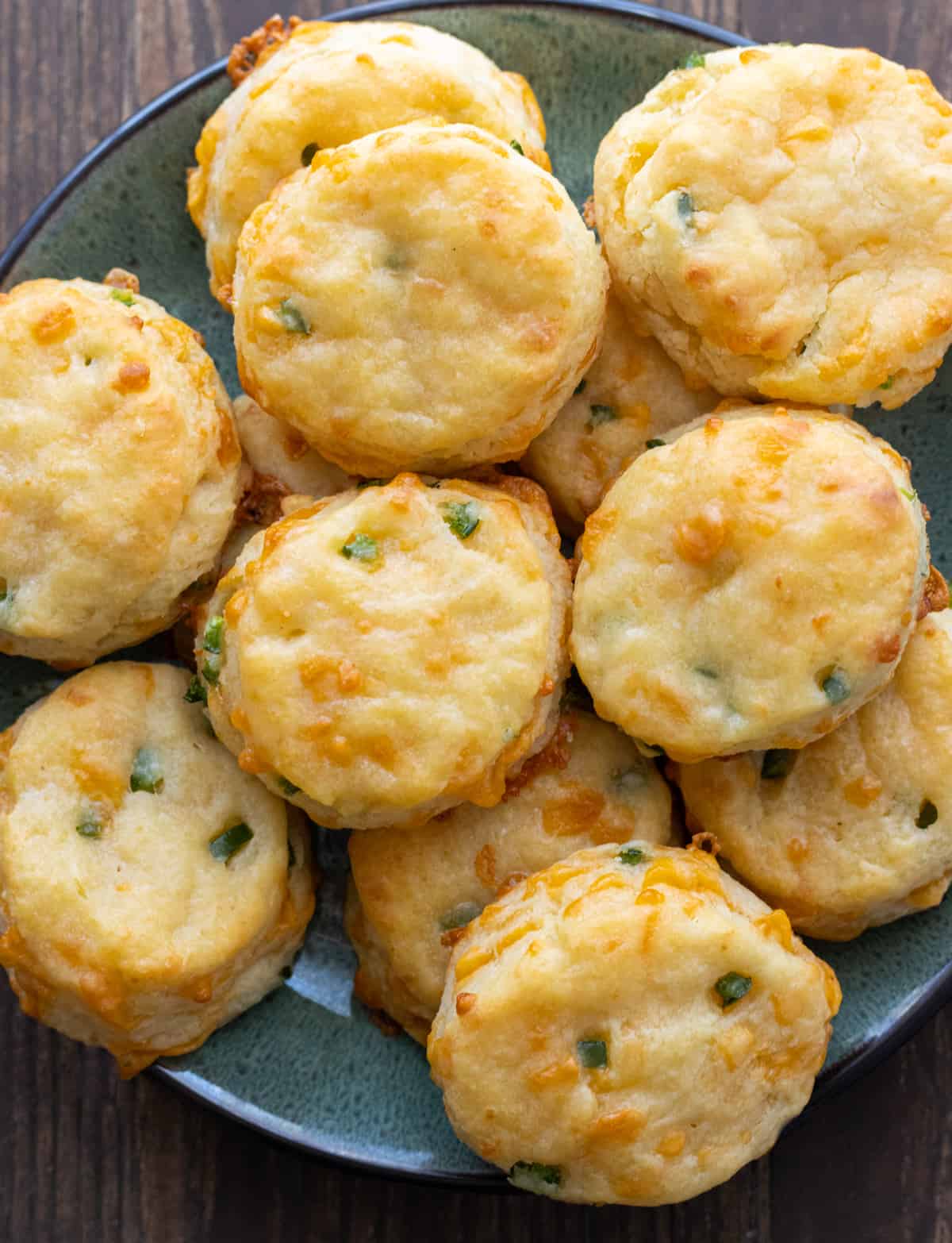 Cheddar jalapeño biscuits piled up on a plate.
