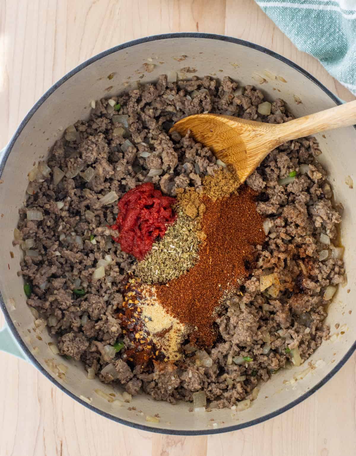 Tomato paste and spices on top of cooked ground meat.