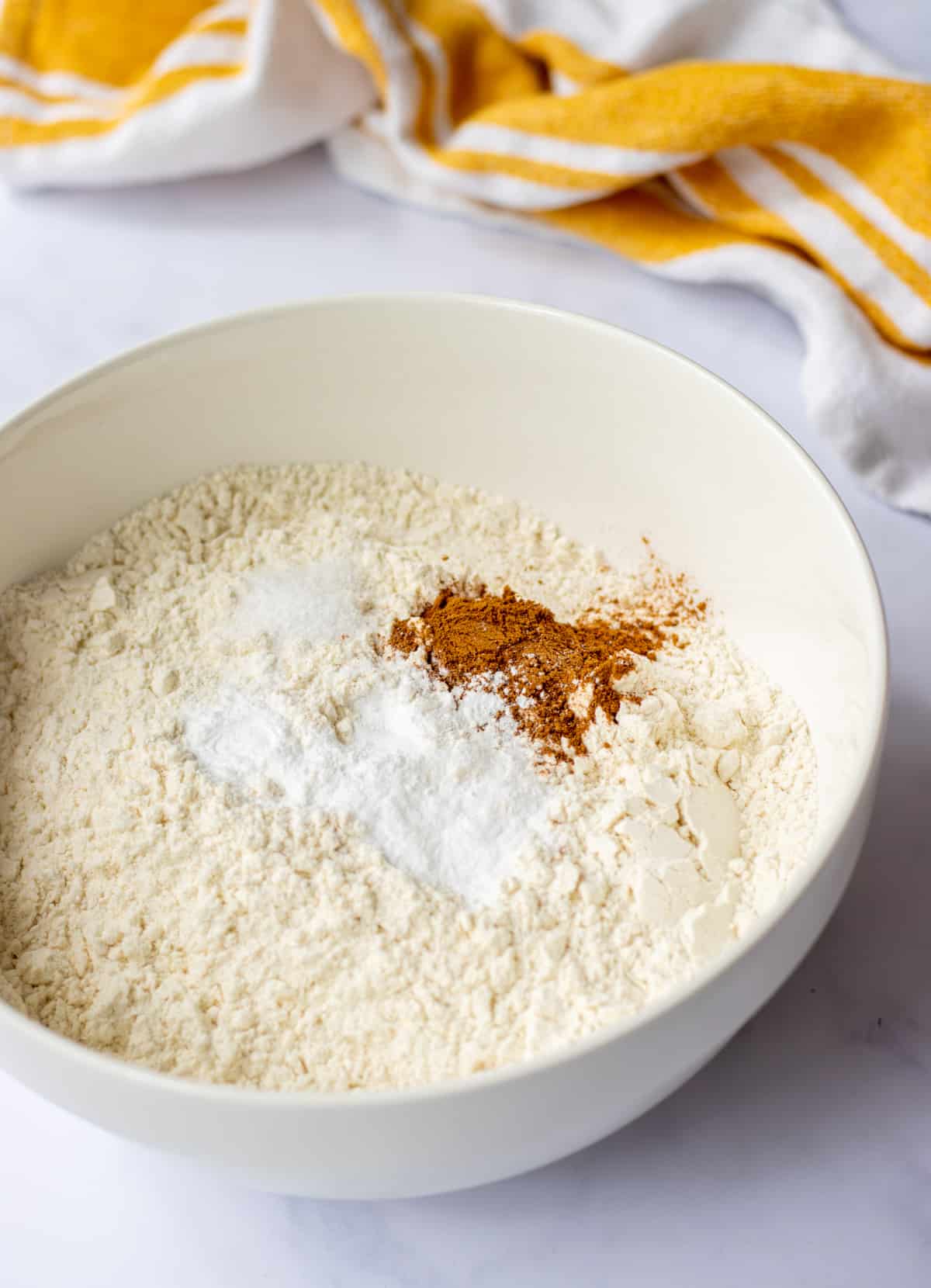 Flour, baking powder, baking soda, cinnamon, and salt in a bowl.