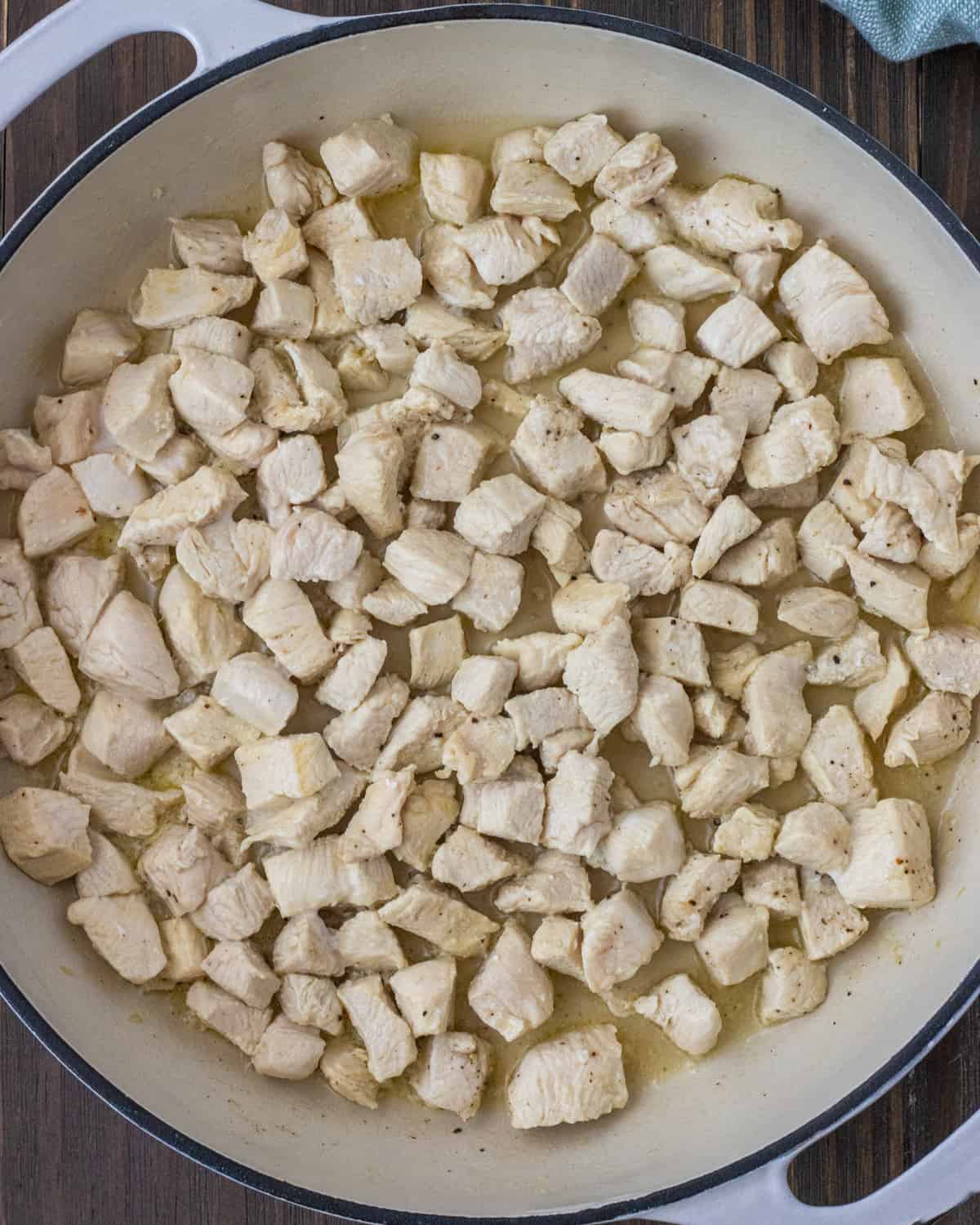 Cooked diced chicken in a skillet.