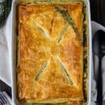 Chicken pot pie with a puff pastry topping with four slits in the top.