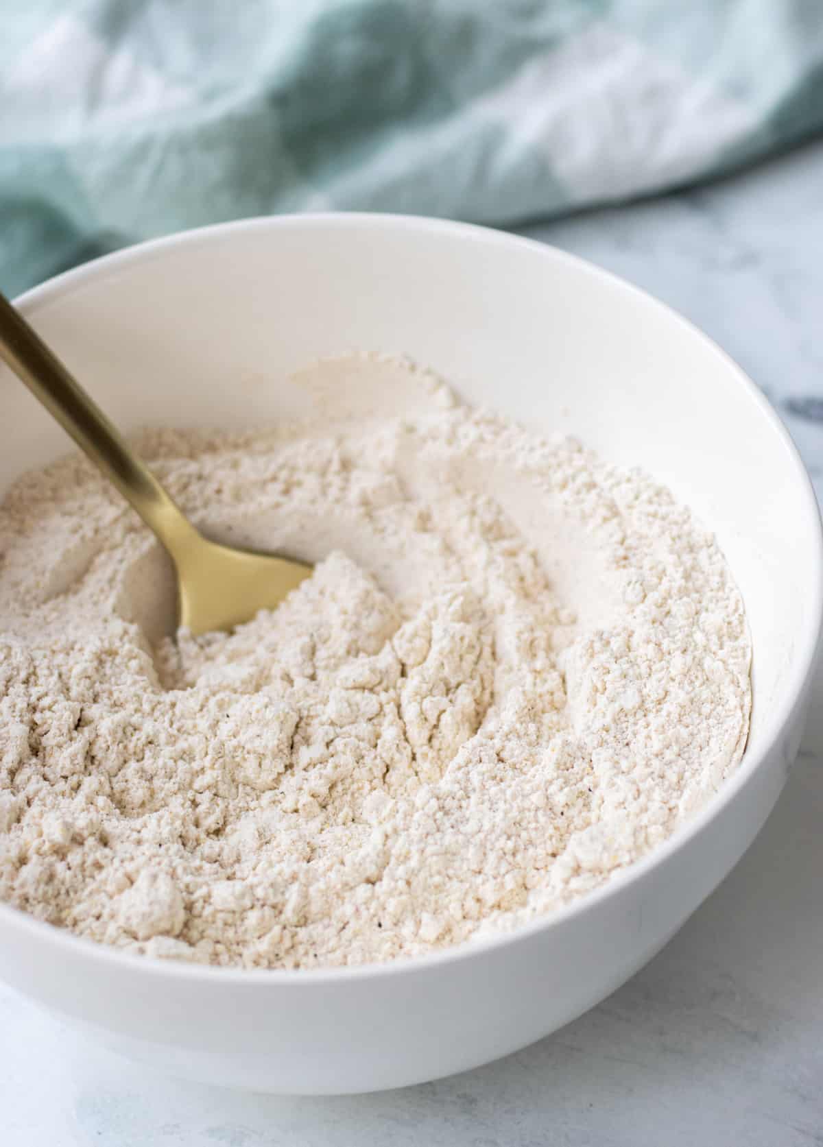 Seasoned flour in a bowl with a spoon.