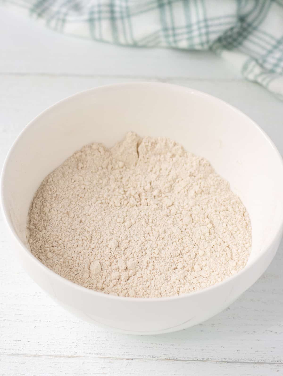 Flour, sugar, baking powder, cinnamon, cardamon, and salt whisked together in a bowl.