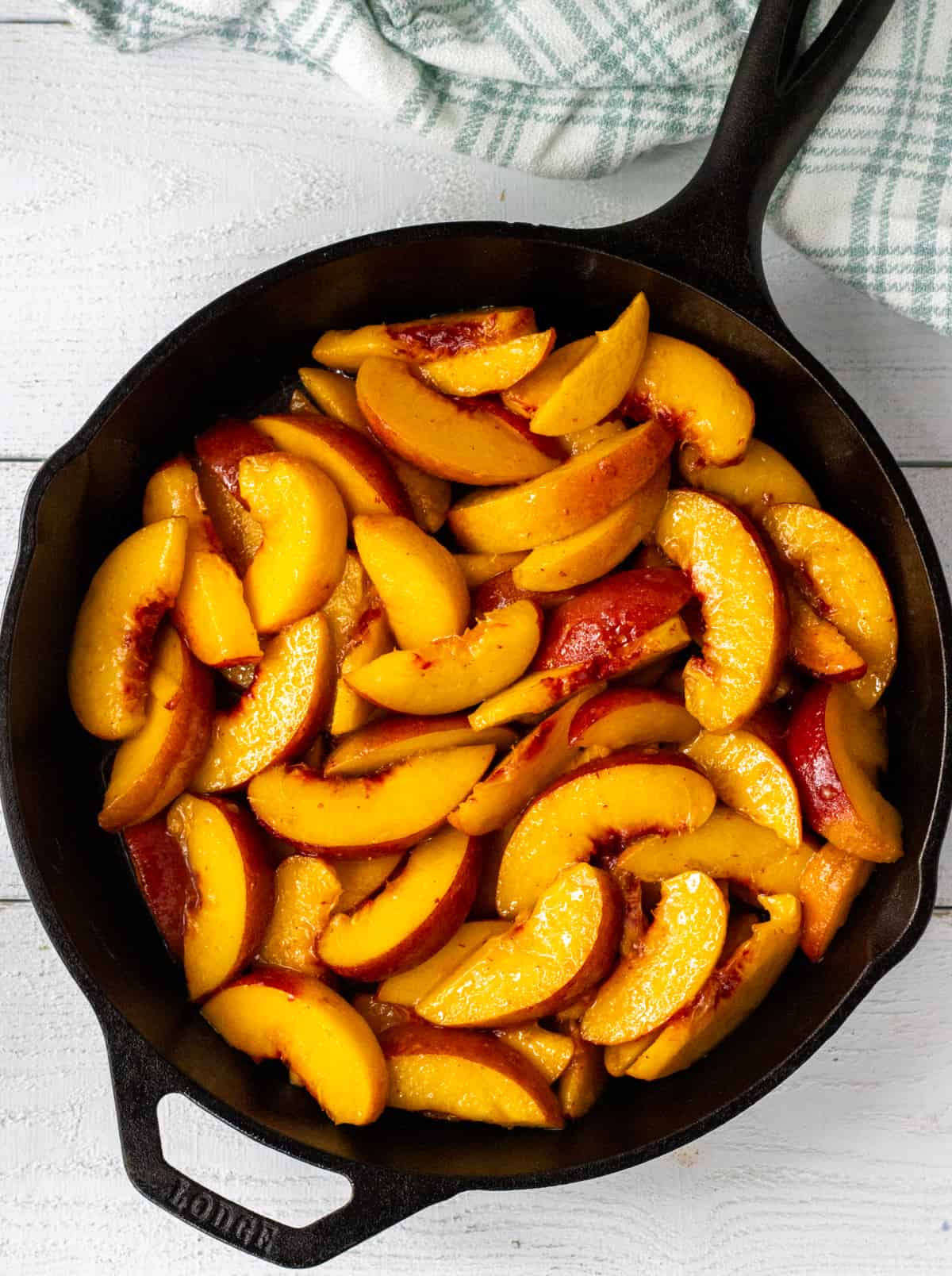 Sliced peaches in a cast iron pan.