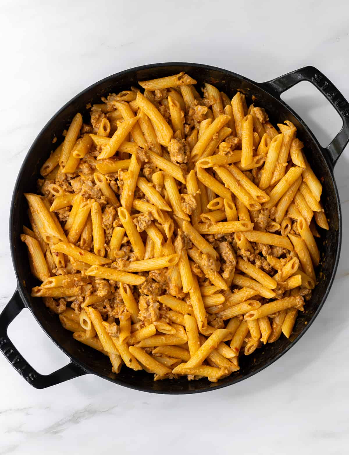 Spicy sausage pasta in a skillet.