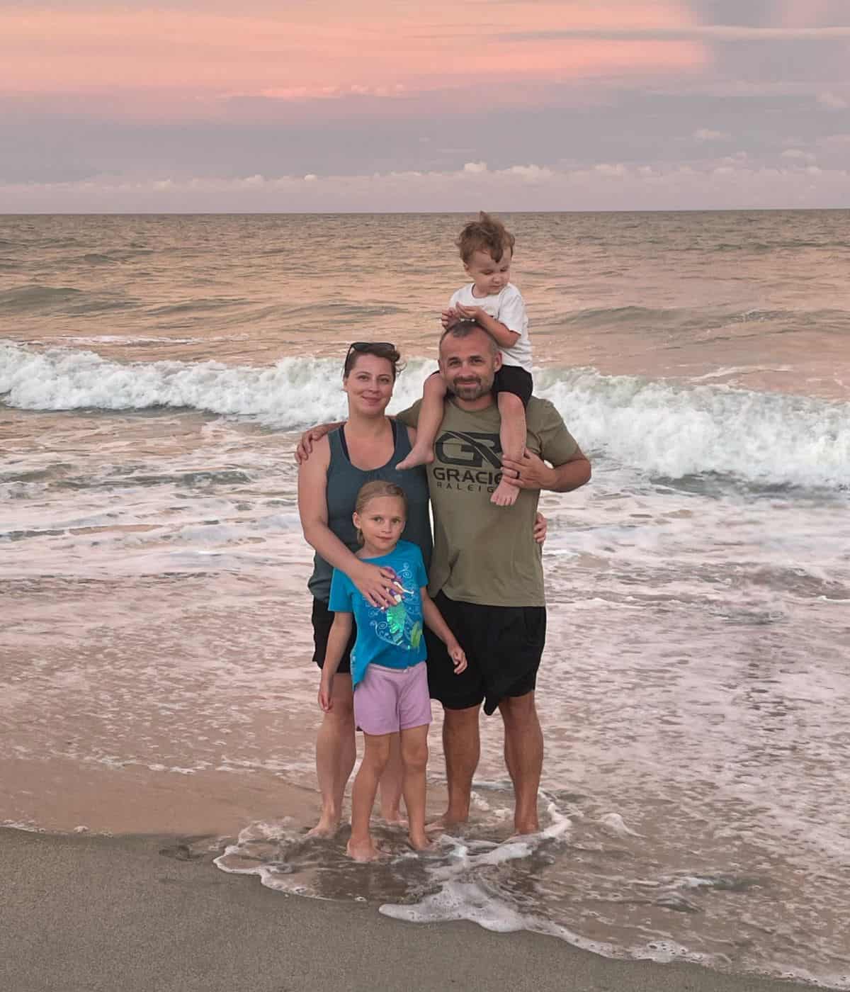 A photo of Alicia with her husband and 2 kids at the beach.