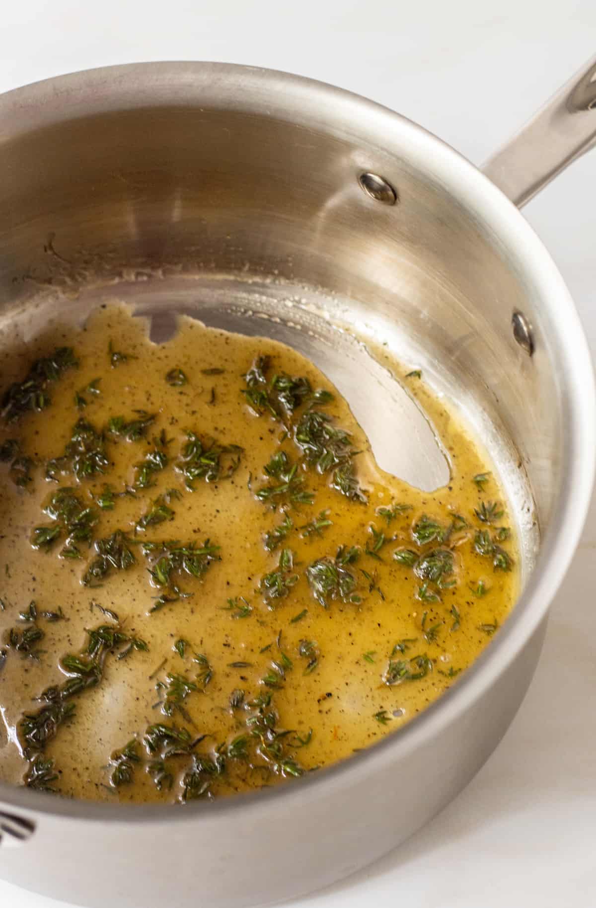 Melted butter, honey, thyme, salt, and pepper in a sauce pan.