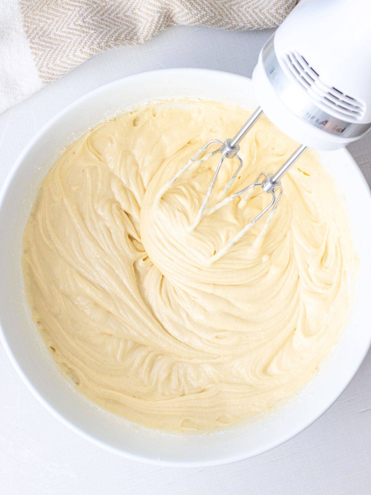 Coffee cake batter in a bowl with electric whisks.