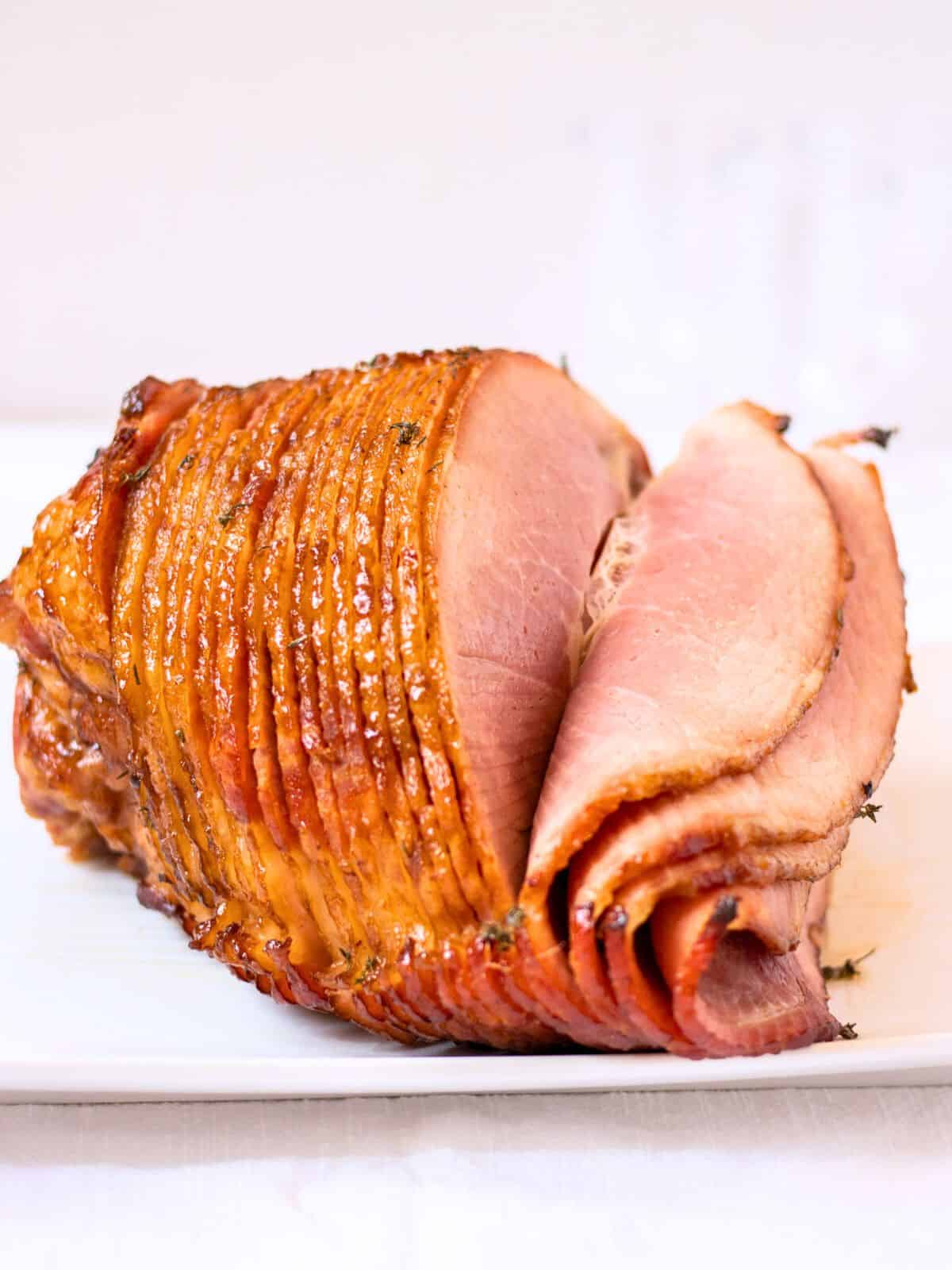 Honey glazed spiral ham on a plate.