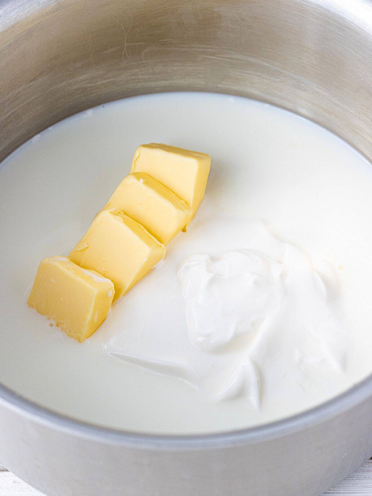 Milk, butter, and sour cream in a saucepan.