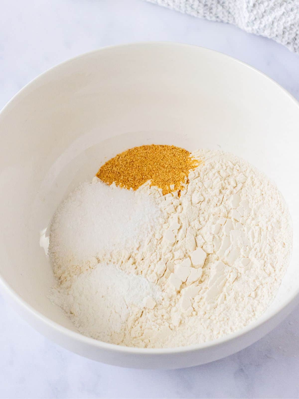 Flour, garlic powder, salt, and baking powder in a bowl.