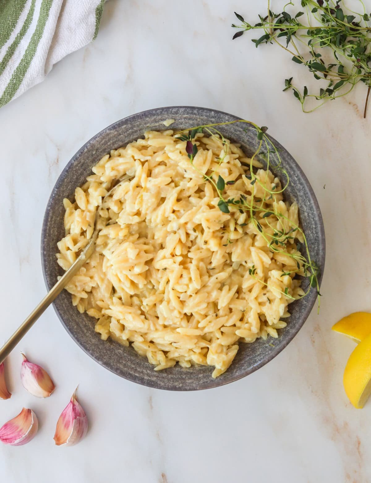 Bowl of creamy lemon orzo with a spoon.