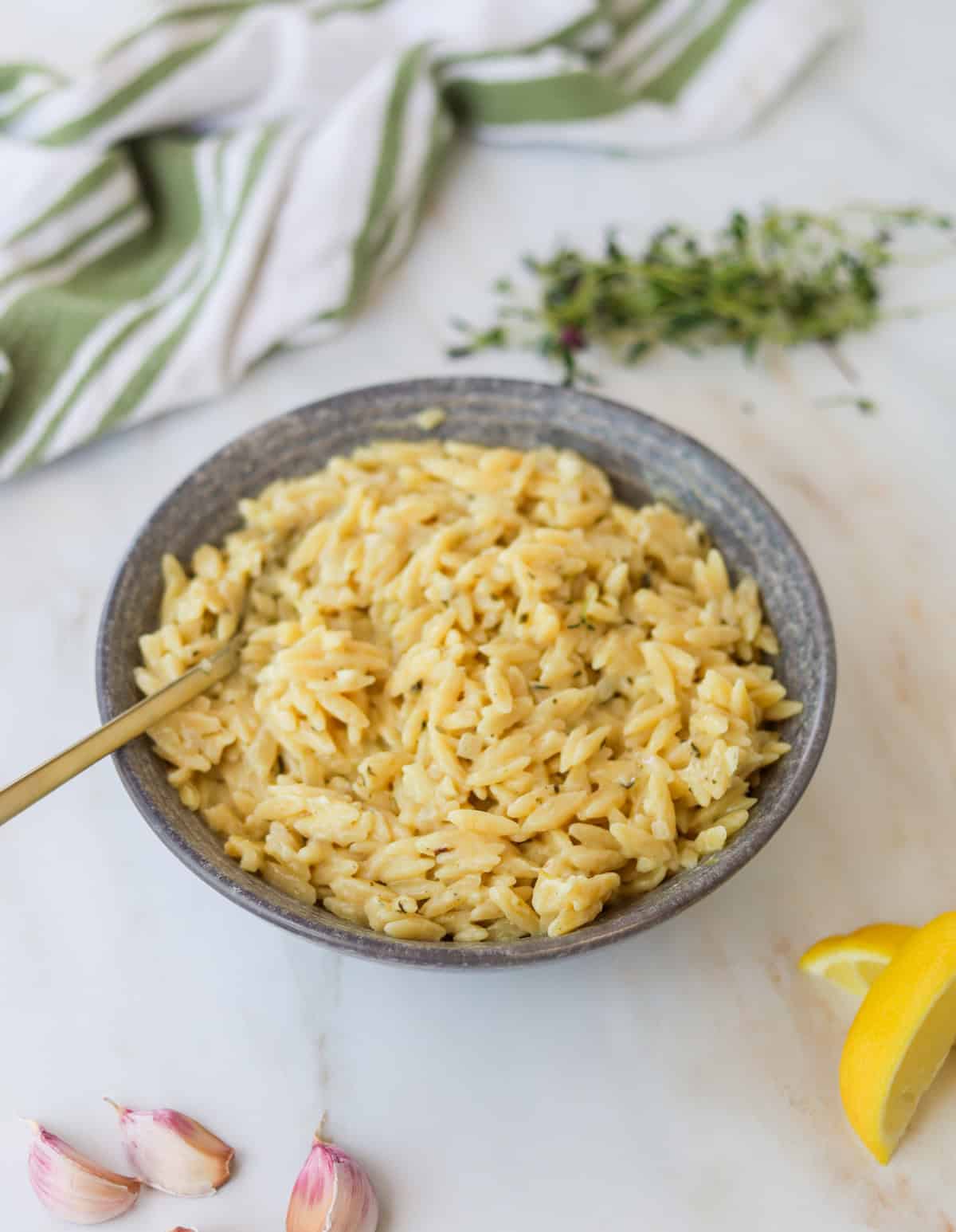 Bowl of creamy lemon orzo with a spoon.